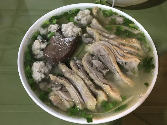 Toppings include duck, pork sausage (mọc), boiled blood pudding (tiết luộc), and bamboo shoots (măng)